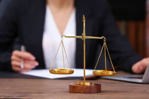 depositphotos_129608012-stock-photo-scales-of-justice-on-wooden